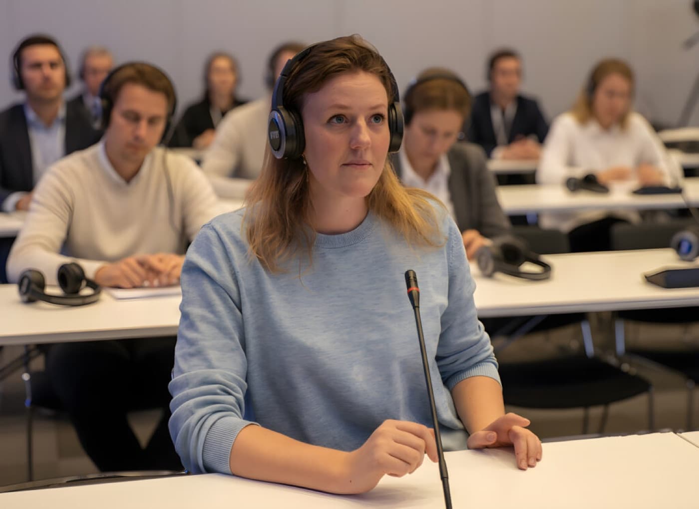 Delegater med profesjonelle tolkeheadset under konferanse