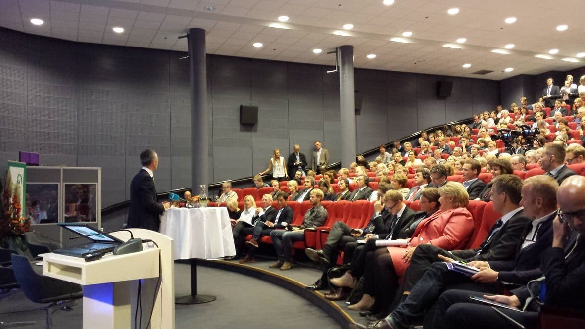Fullsatt auditorium på Felix konferansesenter på Aker Brygge, med taler ved podium og publikum i salen