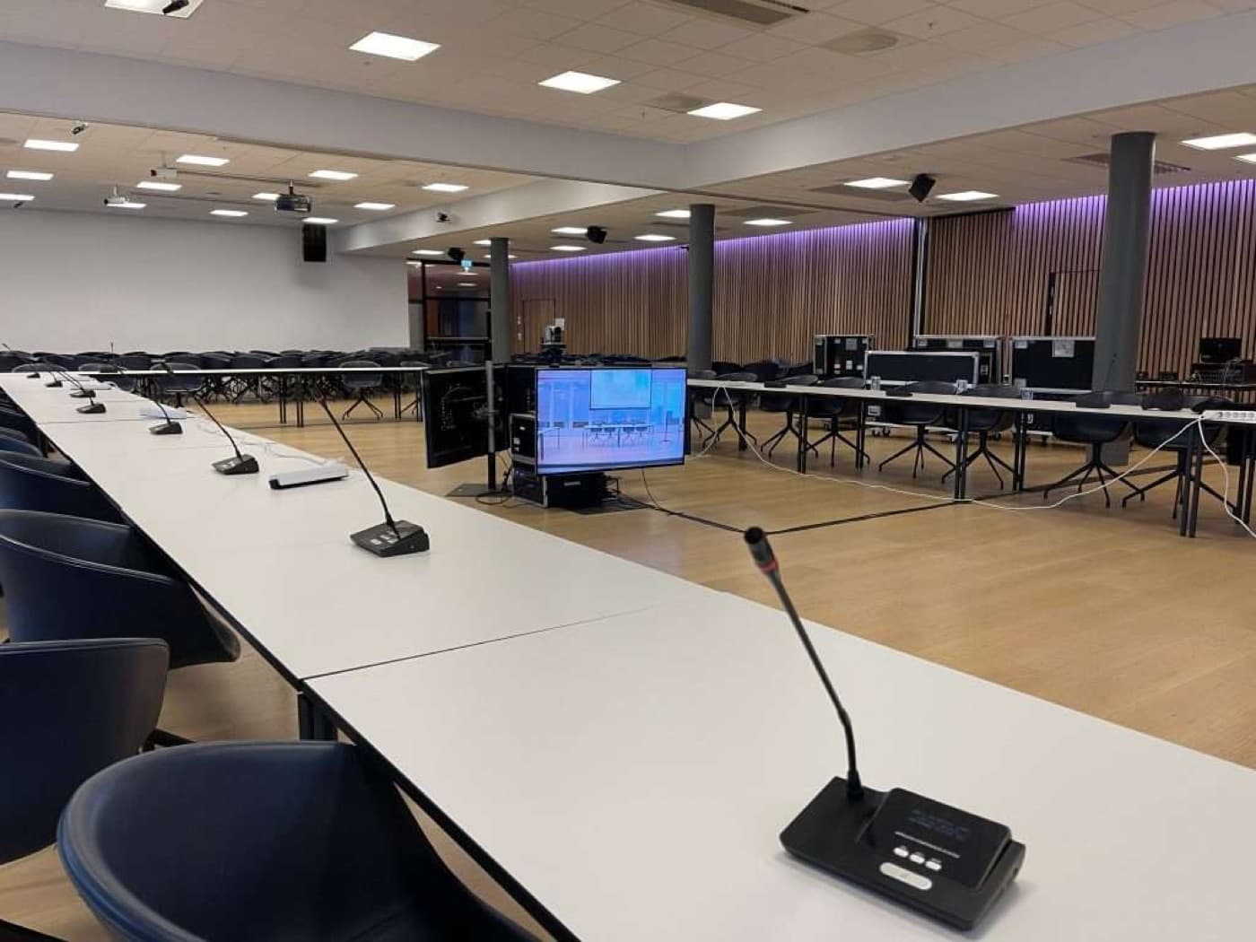 Teknisk rack med lydutstyr og kabler under en konferanserigg