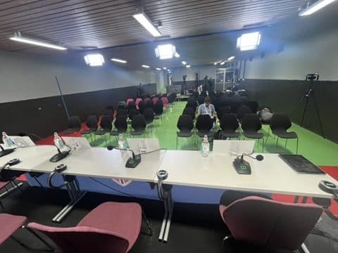Tomt presserom på Ullevaal stadion før en kamp, med mikrofoner klare på bordet